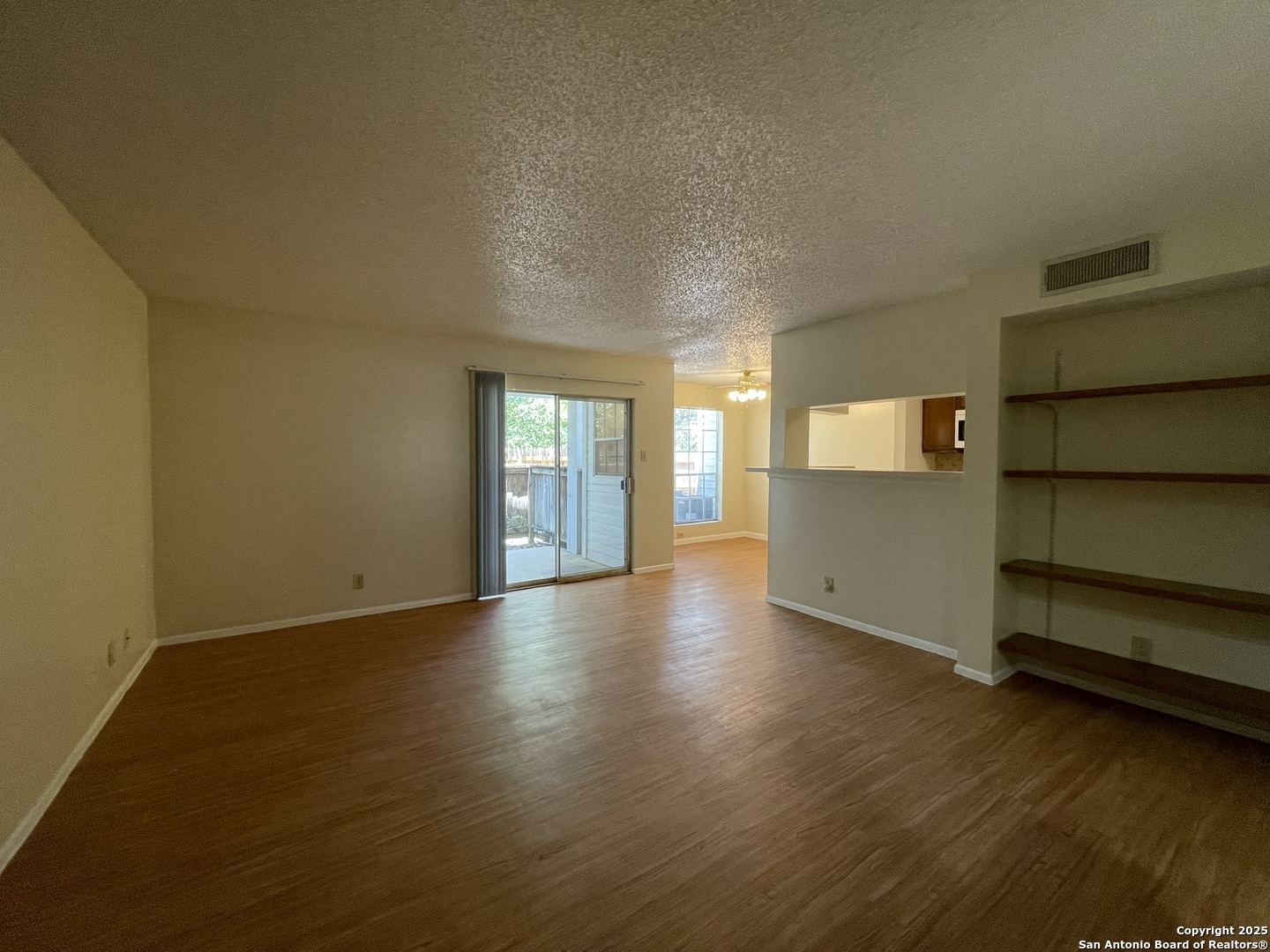 11311 Sir Winston Street, Unit 604 San Antonio, TX 78216 - Photo 4 of 24 an empty room with wooden floor and windows
