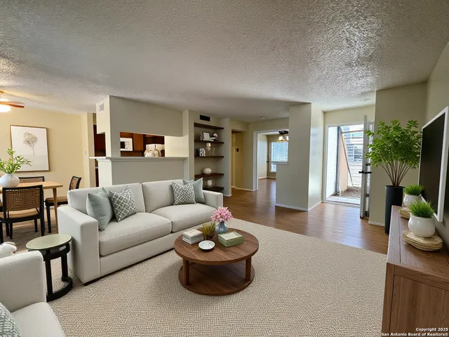 a living room with furniture and a wooden floor