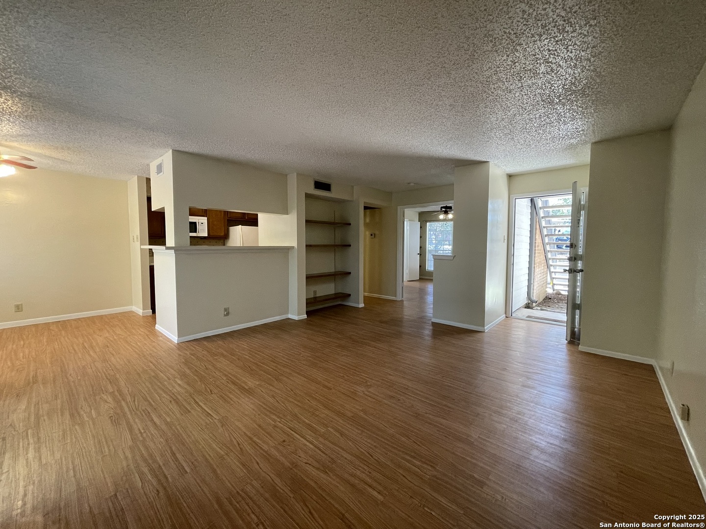 11311 Sir Winston Street, Unit 604 San Antonio, TX 78216 - Photo 6 of 24 an empty room with wooden floor and bathroom view