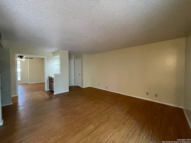 a view of empty room with wooden floor
