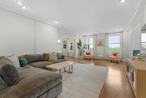 a living room with furniture flat screen tv and wooden floor