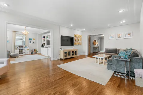 a living room with furniture a flat screen tv and a window