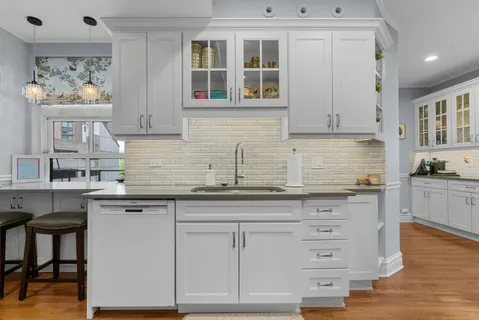 a kitchen with stainless steel appliances granite countertop a stove top oven a sink dishwasher a refrigerator and a oven with wooden floor