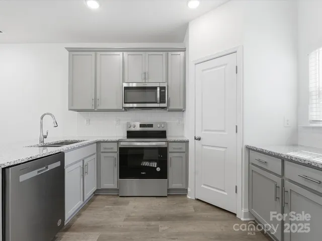 a kitchen with cabinets stainless steel appliances and a sink