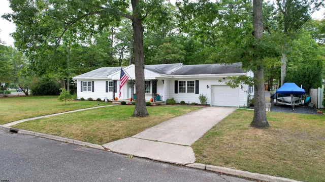 a front view of a house with a garden and trees