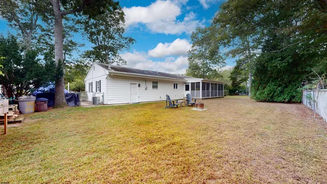 a front view of house with yard and trees in the background