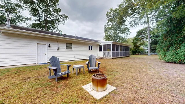 a backyard of a house with barbeque oven table and chairs