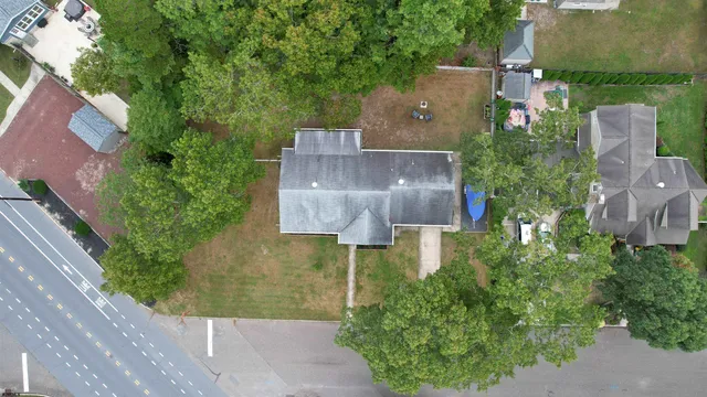 an aerial view of a house with plants and large trees