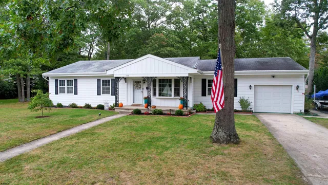 a front view of a house with a yard and trees