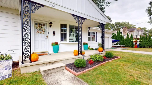 a front view of a house with large garden and plants