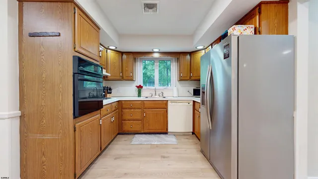 a kitchen with stainless steel appliances granite countertop a refrigerator a sink and dishwasher