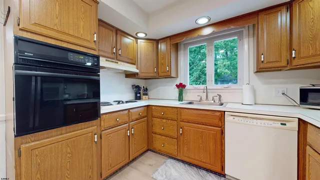 a kitchen with cabinets appliances and a window