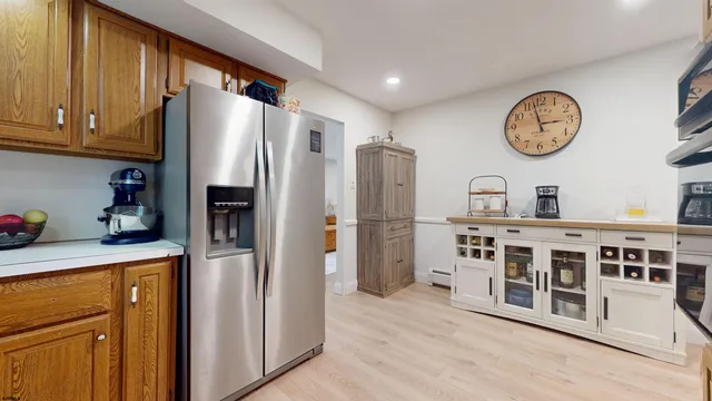 a kitchen with stainless steel appliances granite countertop a refrigerator a stove and a refrigerator with wooden floor