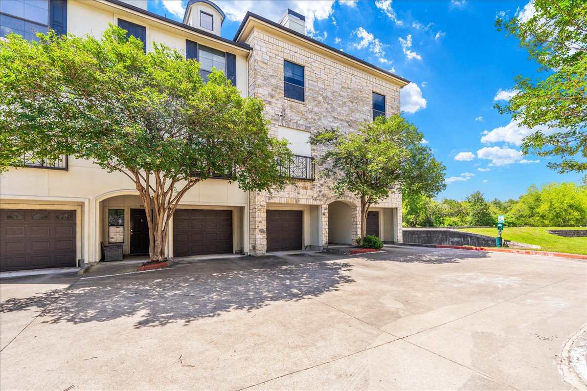 7701 Rialto Boulevard, Unit 91 Austin, TX 78735 - Photo 30 of 39 a front view of a house with a yard and a garage