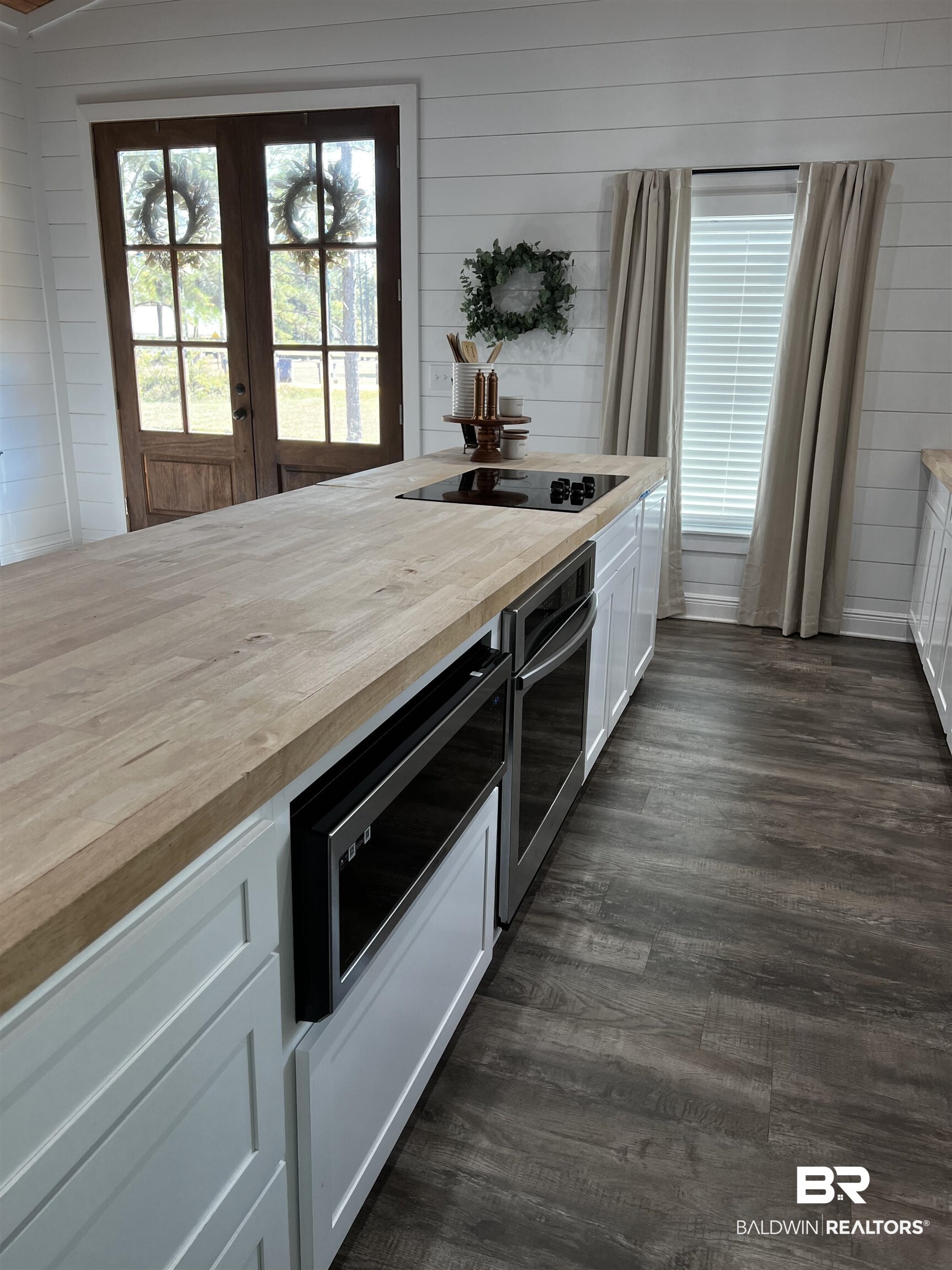 370 Dianne Road Frisco City, AL 36445 - Photo 40 of 41 Kitchen with black electric cooktop, white cabinets, wood counters, wooden walls, and dark hardwood / wood-style flooring
