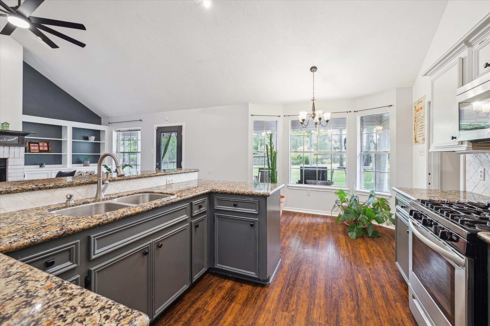 2420 Canter Lane Conroe, TX 77384 - Photo 10 of 24 a kitchen with stainless steel appliances granite countertop a sink stove and wooden floor