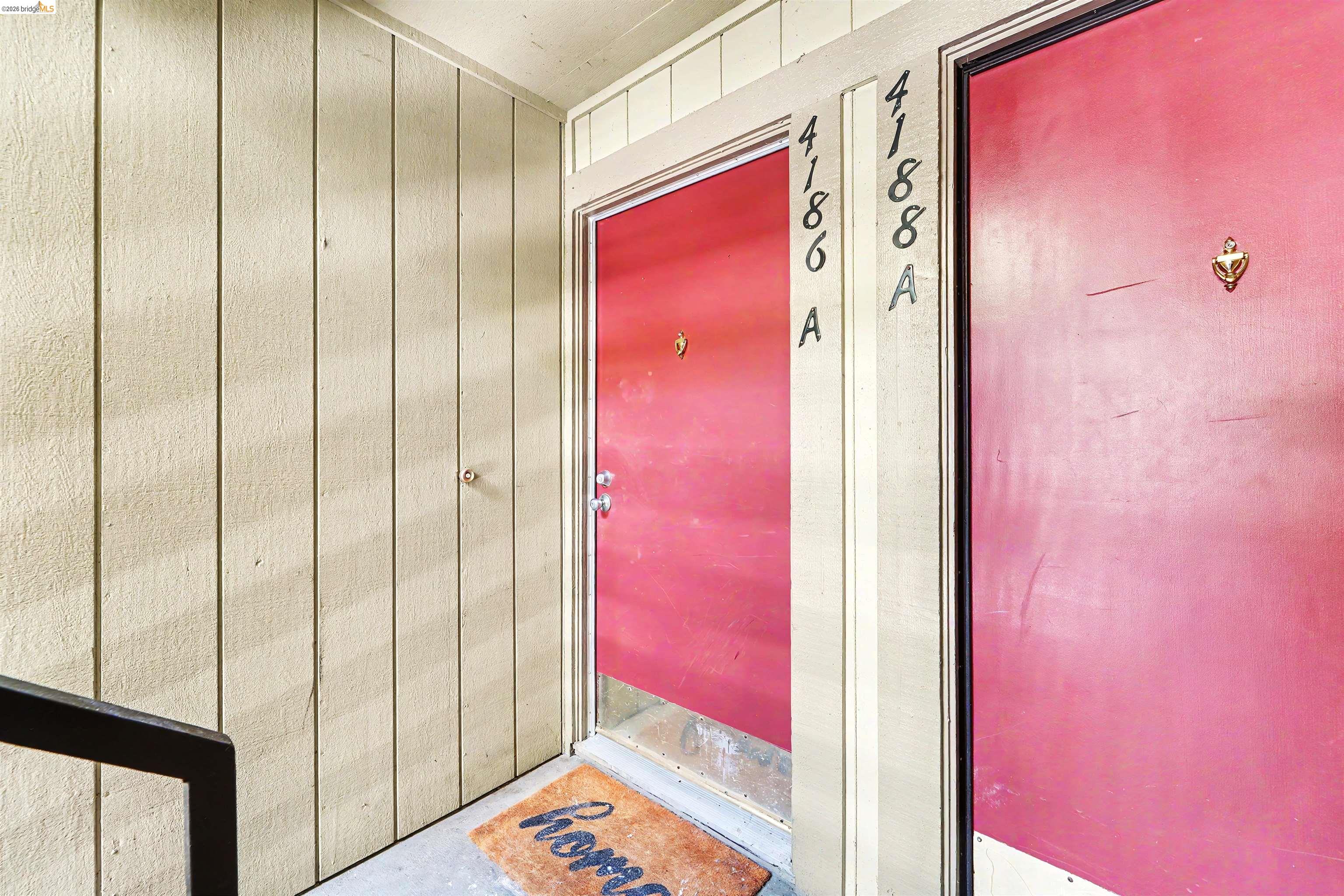 4186 San Pablo Dam Road, Unit A El Sobrante, CA 94803 - Photo 2 of 34 Entryway featuring a bright red door with a partial glass insert, contrasting against vertical wood-panel siding