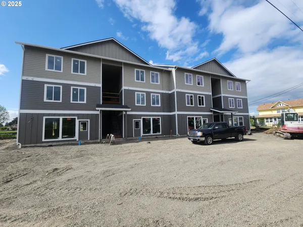 a front view of a house with cars parked