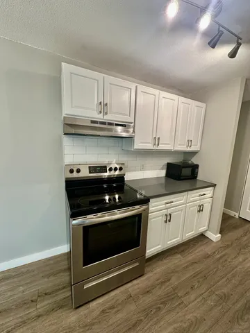 a kitchen with stainless steel appliances a stove top oven and cabinets