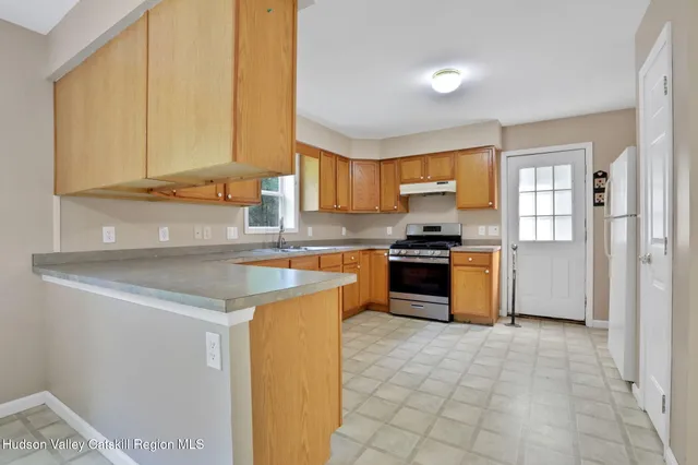 a kitchen with stainless steel appliances granite countertop a stove a sink and a refrigerator