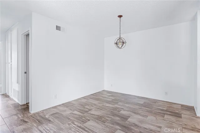 a view of a room with wooden floor and ceiling fan
