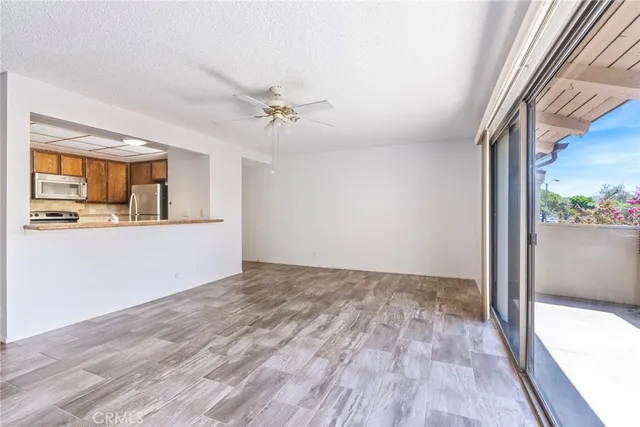 a view of a kitchen with wooden floor and a ceiling fan