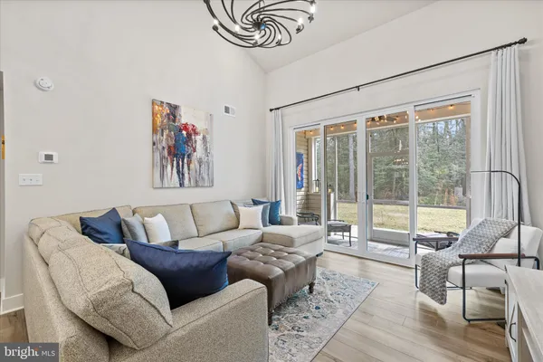 a spacious bedroom with a bed a couch and a chandelier