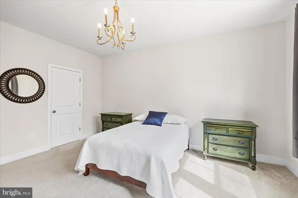 a view of a bedroom with wooden floor and a bookshelf