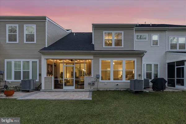 a front view of a building with a garden and trees