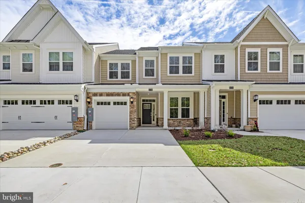 a kitchen with stainless steel appliances a table chairs refrigerator and microwave