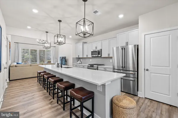 a large kitchen with stainless steel appliances lots of counter space and wooden floor