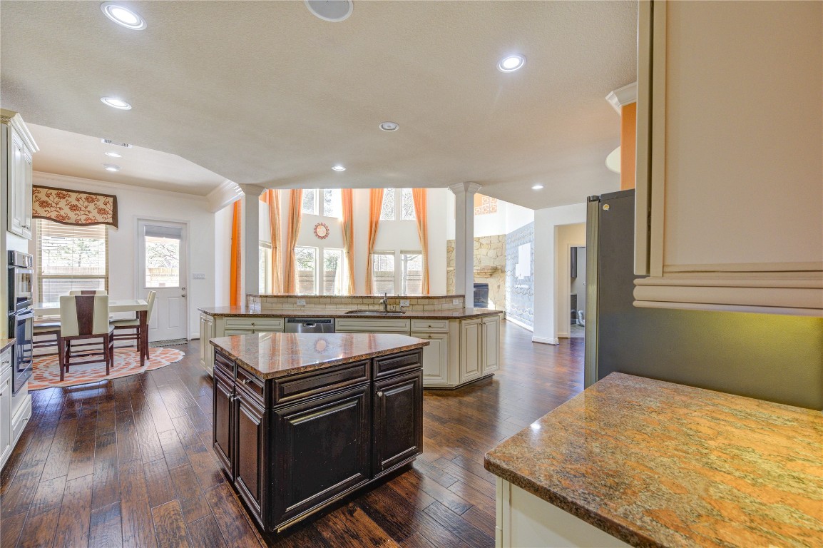 3806 Sims Pointe Court Fulshear, TX 77441 - Photo 13 of 50 a kitchen with stainless steel appliances granite countertop a stove and a wooden floors