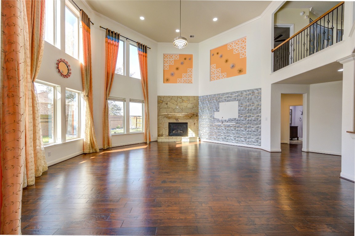 3806 Sims Pointe Court Fulshear, TX 77441 - Photo 20 of 50 an empty room with wooden floor and fireplace