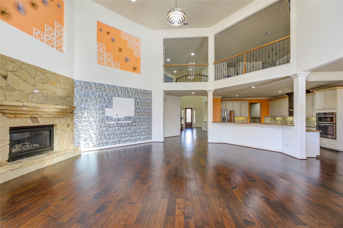 3806 Sims Pointe Court Fulshear, TX 77441 - Photo 21 of 50 a view of an empty room with wooden floor and a fireplace