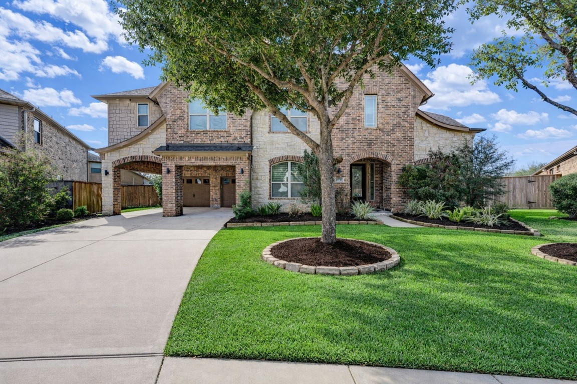 3806 Sims Pointe Court Fulshear, TX 77441 - Photo 46 of 50 a front view of a house with a yard and a fountain
