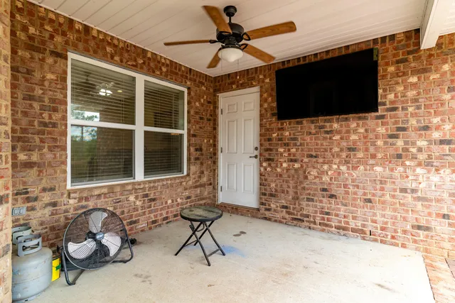 a view of a house with a backyard porch and wooden fence
