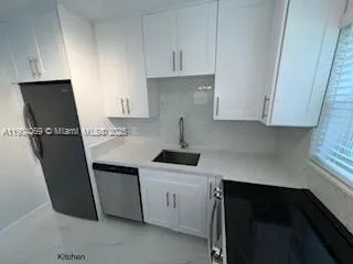 a kitchen that has a sink a stove and window