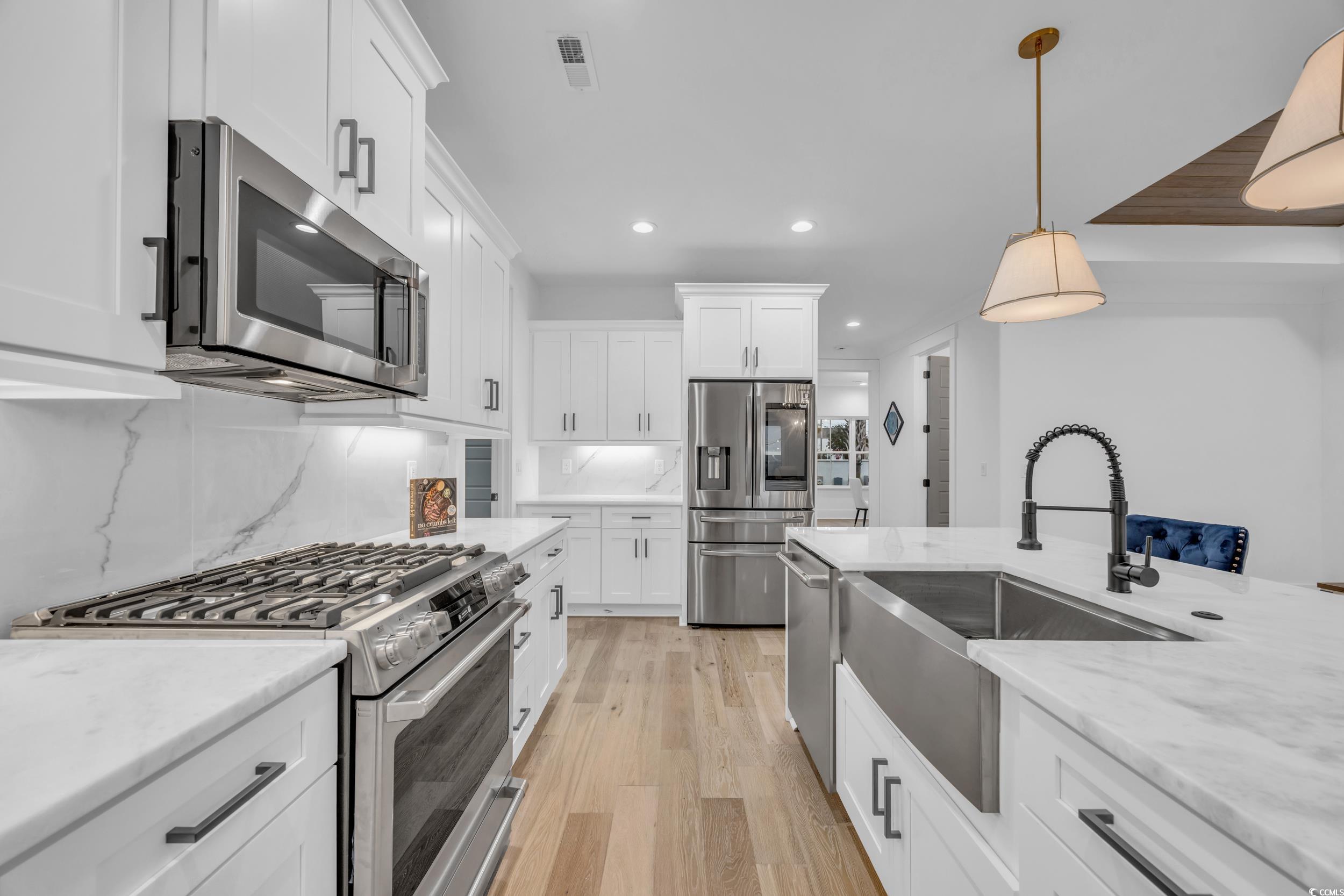 6703 Ocean Breeze Loop Myrtle Beach, SC 29572 - Photo 19 of 40 Kitchen featuring white cabinetry, hanging light f