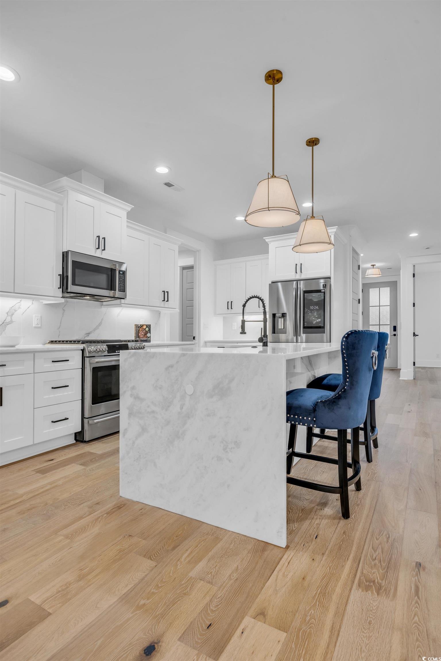 6703 Ocean Breeze Loop Myrtle Beach, SC 29572 - Photo 22 of 40 Kitchen with white cabinets, an island with sink,