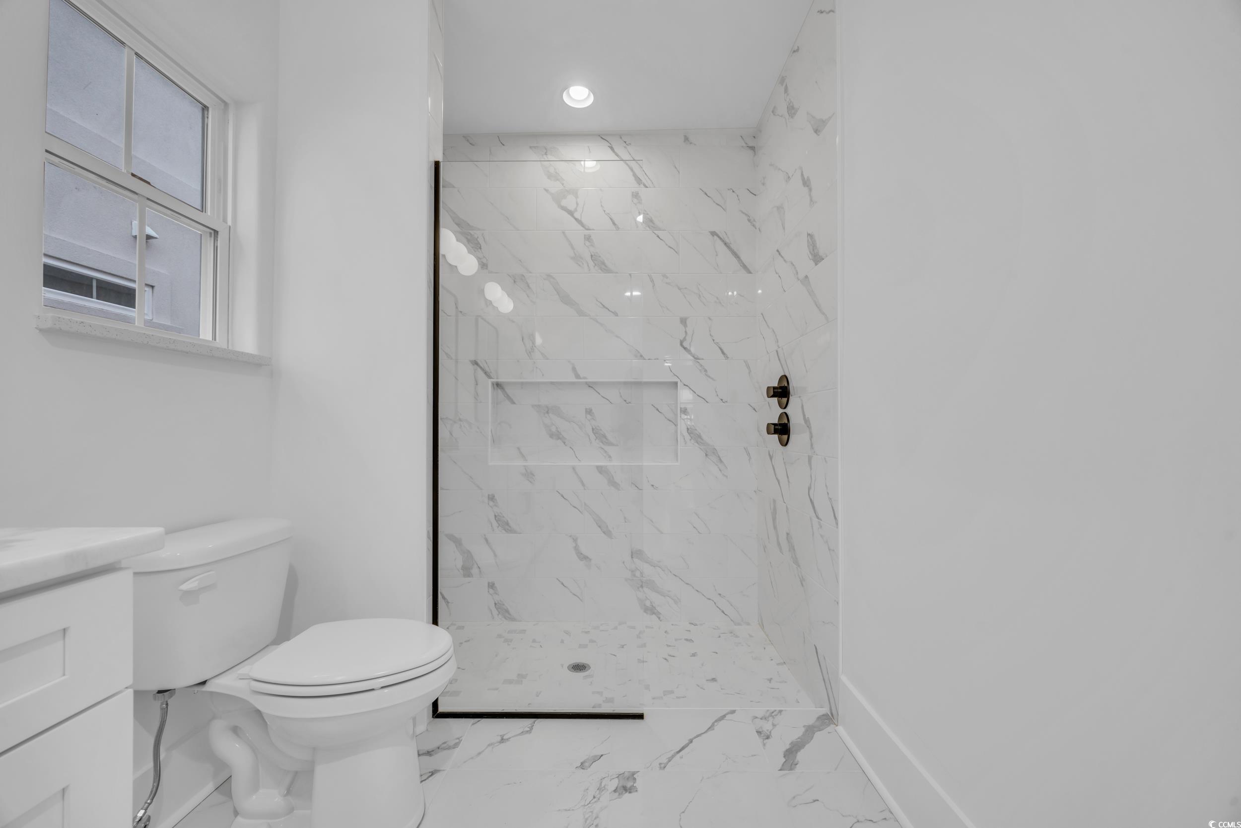6703 Ocean Breeze Loop Myrtle Beach, SC 29572 - Photo 30 of 40 Bathroom featuring vanity, toilet, and tiled showe