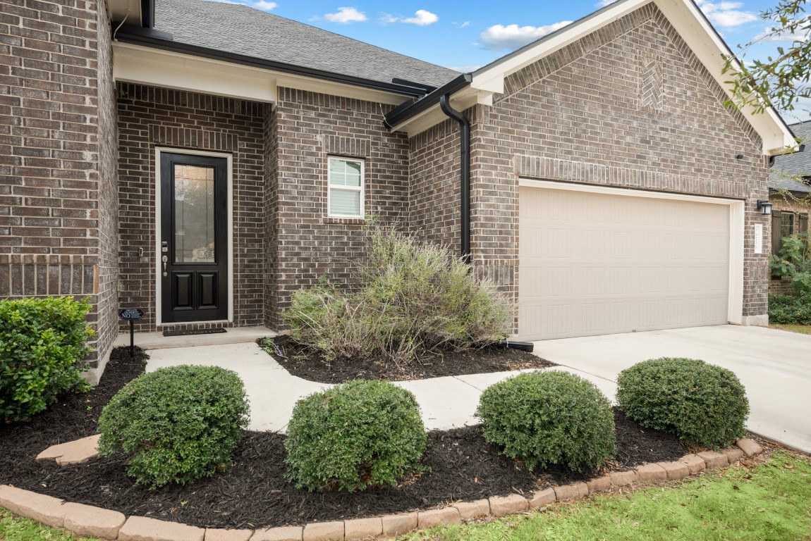 216 Emerald Garden Road San Marcos, TX 78666 - Photo 3 of 38 View of front of house with brick siding, concrete driveway, and an attached garage
