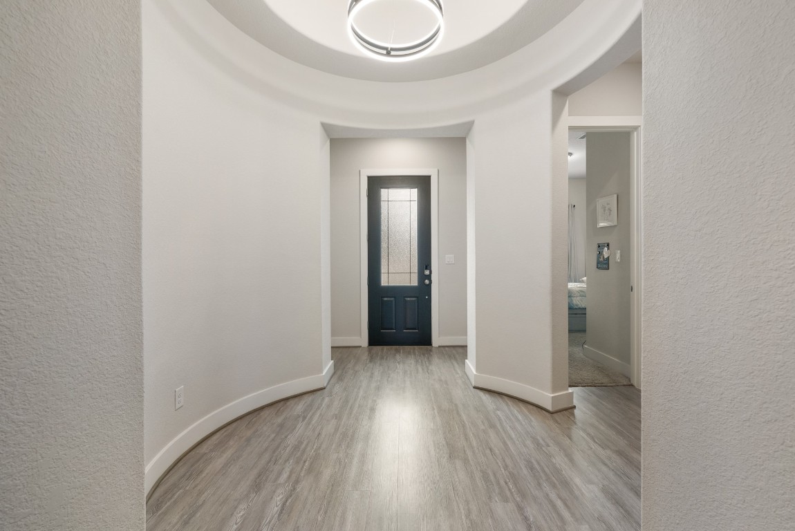 216 Emerald Garden Road San Marcos, TX 78666 - Photo 5 of 38 Foyer entrance with a textured wall, light wood-style floors, and arched walkways