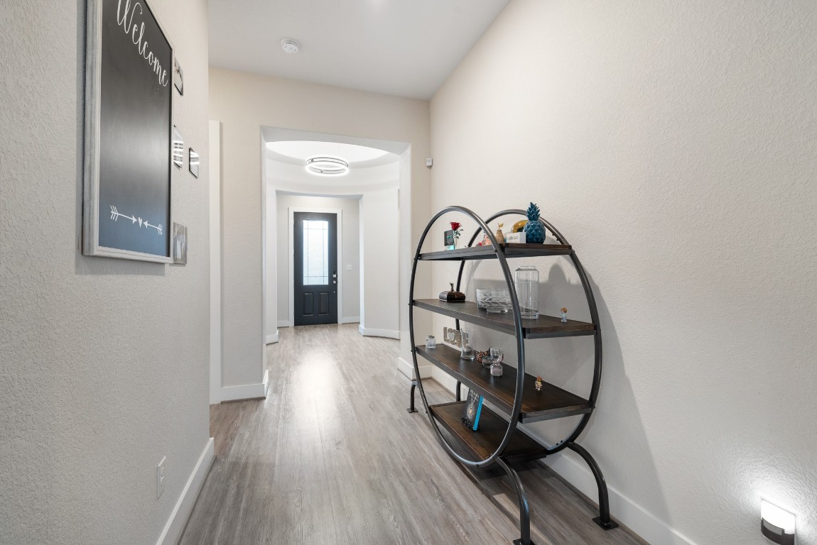 216 Emerald Garden Road San Marcos, TX 78666 - Photo 7 of 38 Hallway with light wood finished floors and a textured wall