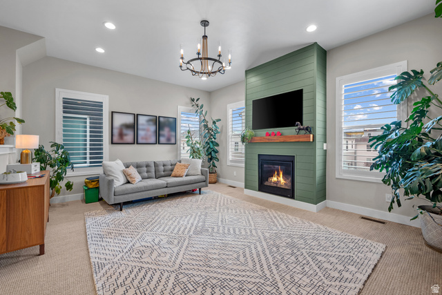 Undisclosed Address South Jordan, UT 84009 - Photo 1 of 1 Living area featuring light carpet, a large fireplace, hanging lights, and healthy amount of natural light