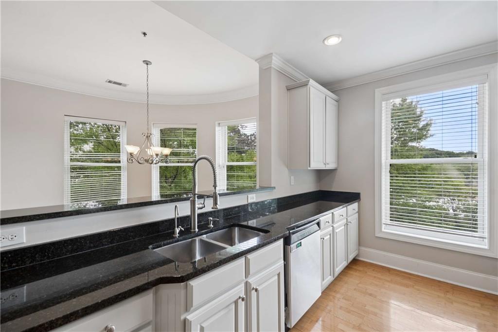 560 Dutch Valley Road Northeast, Unit 311 Atlanta, GA 30324 - Photo 18 of 44 a kitchen with granite countertop a sink and a window