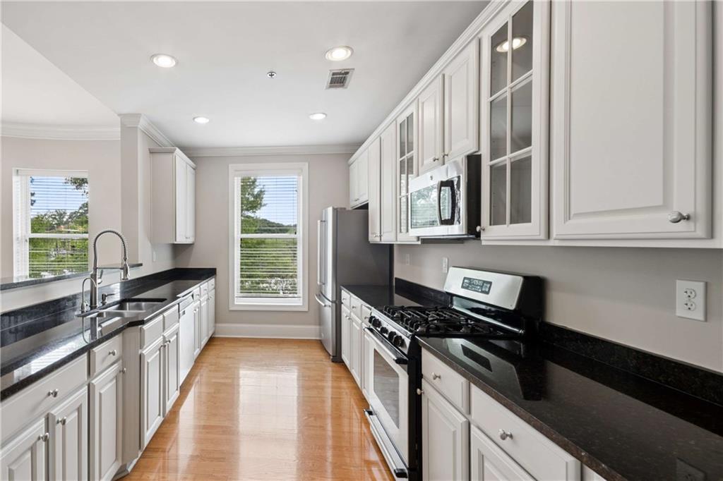 560 Dutch Valley Road Northeast, Unit 311 Atlanta, GA 30324 - Photo 19 of 44 a kitchen with stainless steel appliances a sink stove and cabinets