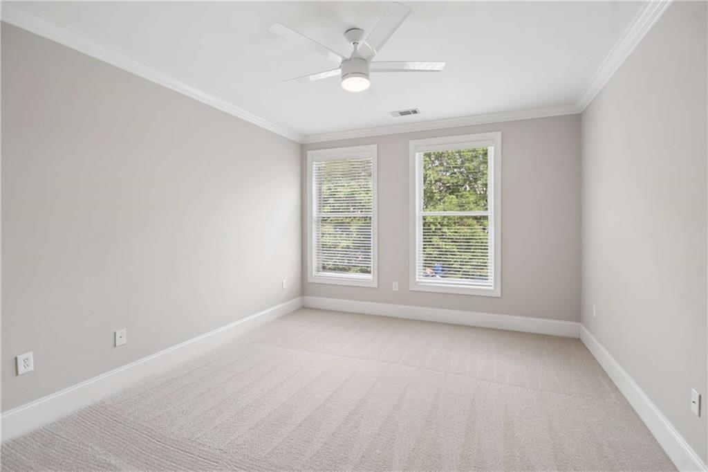 560 Dutch Valley Road Northeast, Unit 311 Atlanta, GA 30324 - Photo 20 of 44 an empty room with a window and a ceiling fan