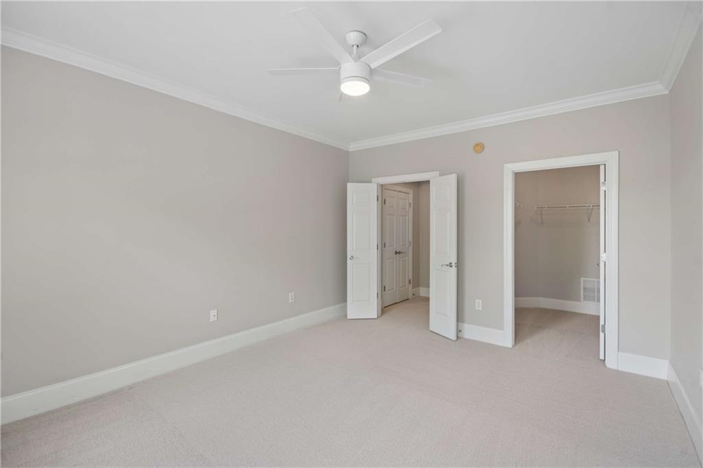 560 Dutch Valley Road Northeast, Unit 311 Atlanta, GA 30324 - Photo 21 of 44 an empty room with closet and a ceiling fan