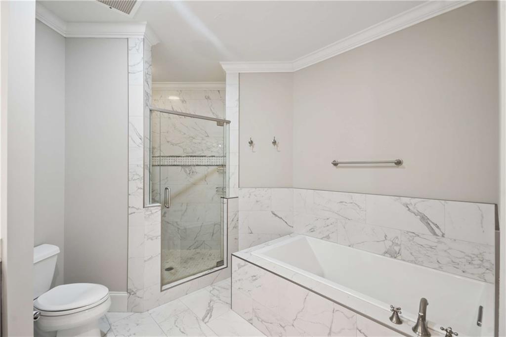 560 Dutch Valley Road Northeast, Unit 311 Atlanta, GA 30324 - Photo 24 of 44 a bathroom with a bathtub and toilet