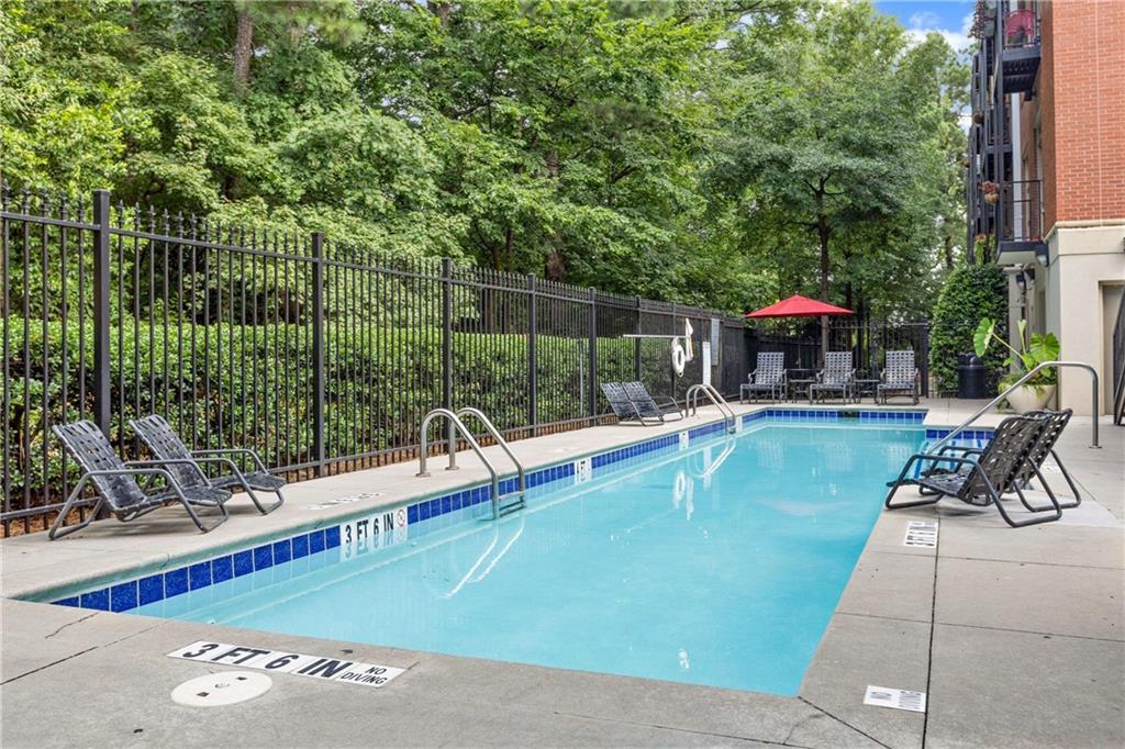 560 Dutch Valley Road Northeast, Unit 311 Atlanta, GA 30324 - Photo 35 of 44 a view of a swimming pool with a patio and a garden
